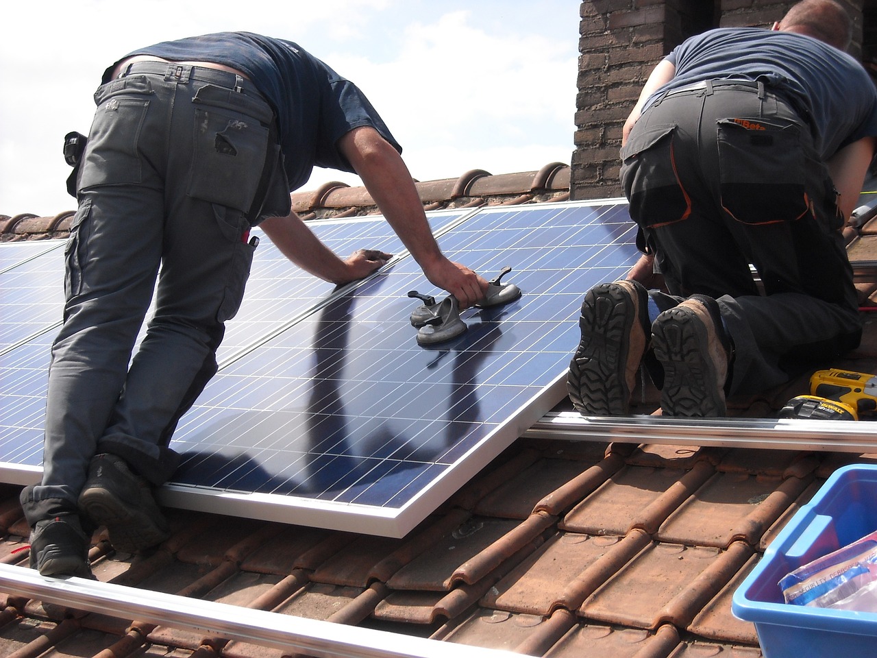 Men installing solar panels on a roof