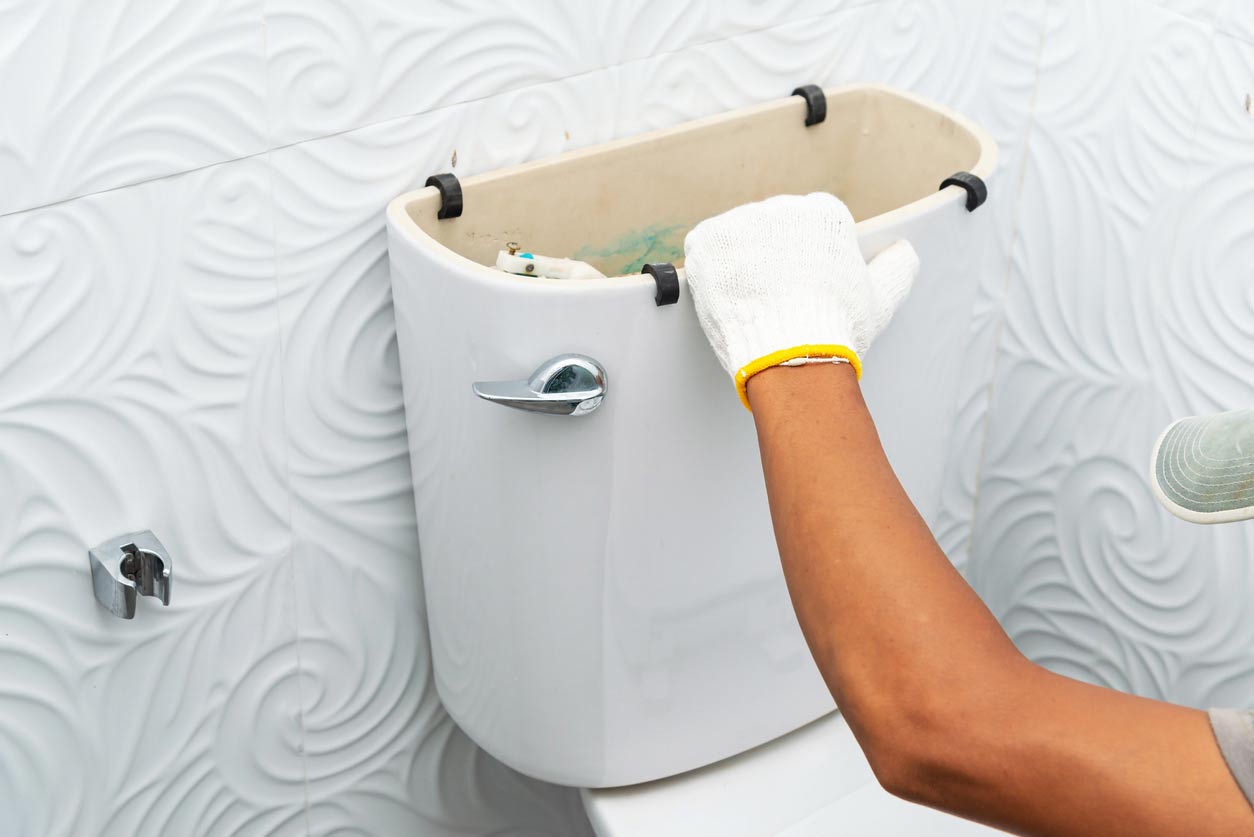 a repairman setting up a white toilet in a white bathroom