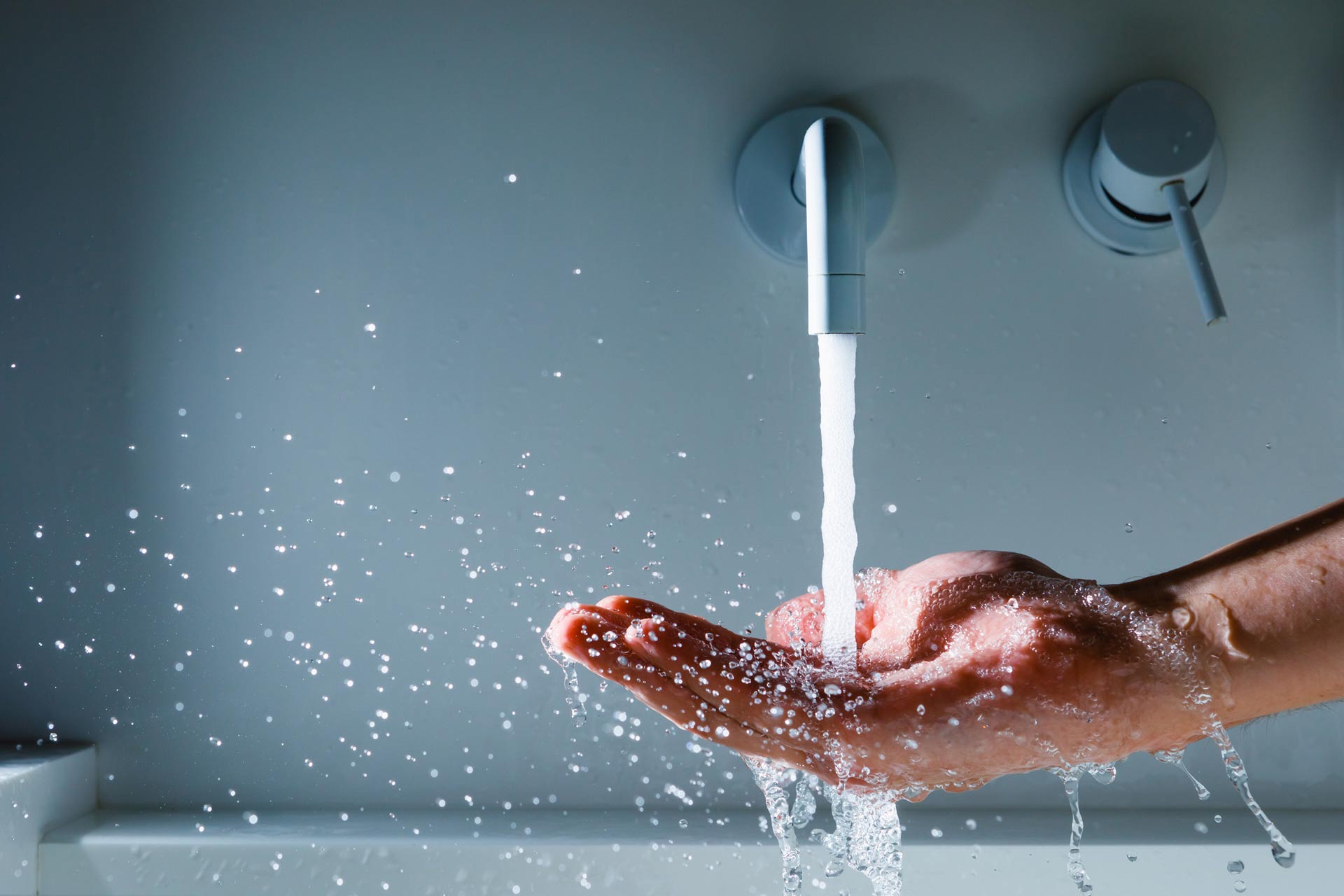 water from a faucet splashing into a cupped hand