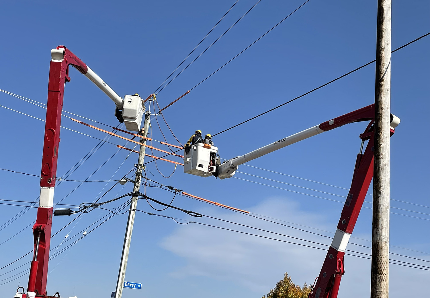 Electric workers in cherry pickers working on power lines