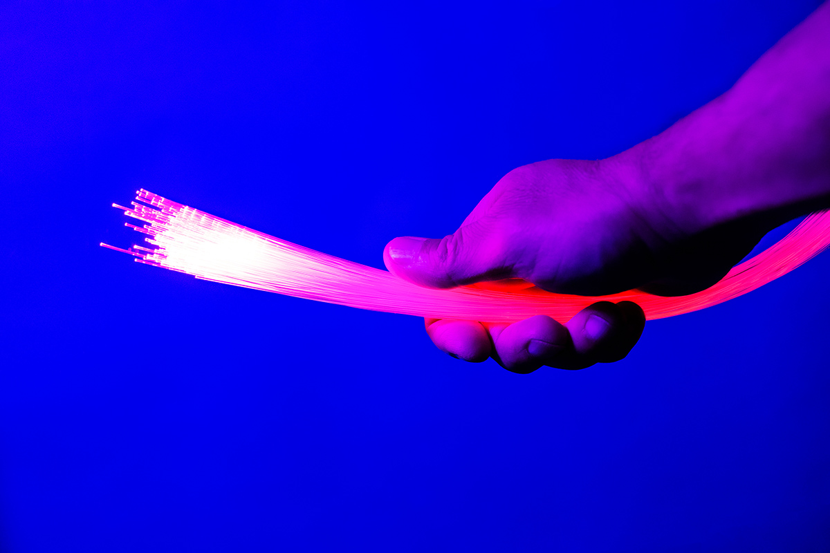 Man's hand holding bunch of fiber optic wires